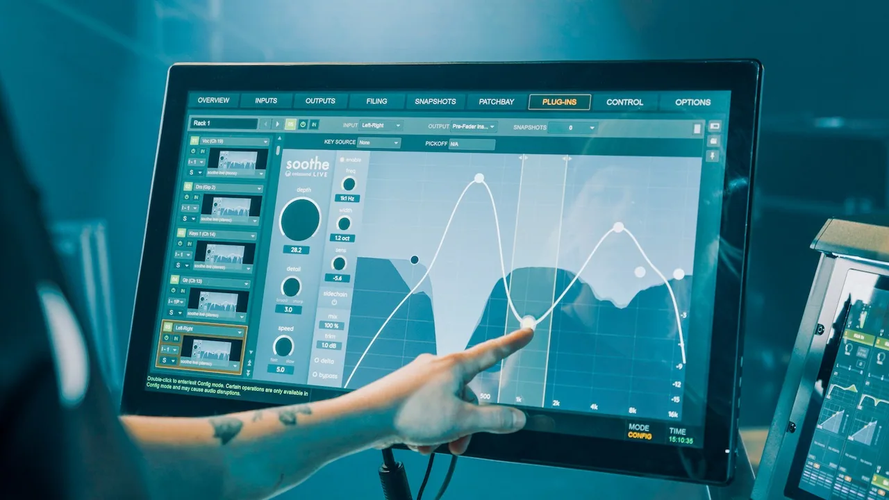 soothe live on an Avid console touchscreen: a finger drags a band node on the frequency graph, with the depth, detail and speed knobs and the band column on the left.